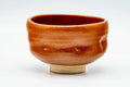 Front view of the aka-raku chawan showing the glossy red glaze