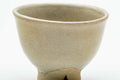 Close-up of a single teacup, showing the soft beige glaze.