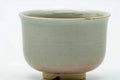 Close-up of the cup body showing the soft beige Hagi glaze above the exposed clay foot.
