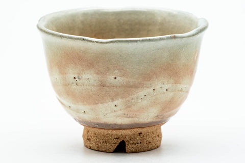 Close-up of one teacup showing the dark beige glaze and pink gohonte spotting.