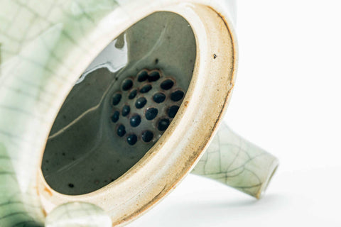 Interior view of the green celadon Obori Soma kyusu showing the perforated strainer holes, with the lid removed