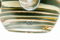 Close-up of the green-and-brown nerikomi marbling and the weathered surface of the clay.