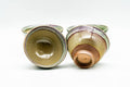 Overhead three-quarter view of the four cups, looking down into their glossy glazed interiors.