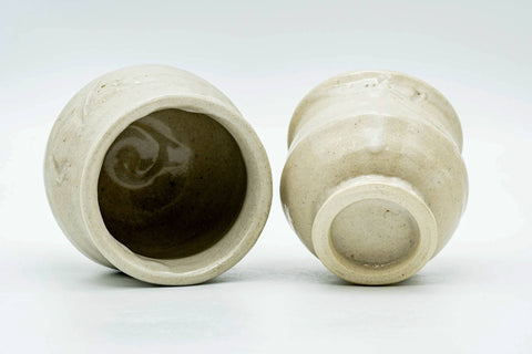 The pair shown with one cup tipped to reveal its interior and foot beside the other's base.