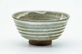 Side view of the spiraling chawan, showing the ridged grey-white glaze wrapping around the body.