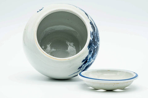 The water bowl with its pierced lid lying flat beside it, showing the open interior.