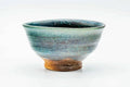 Slightly elevated front view showing the bowl's rounded form and streaked turquoise glaze.