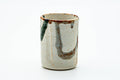 The cup from another angle, showing the abstract brushwork.