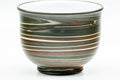 Front view of the nerikomi yunomi emphasizing the layered green, red and yellow pattern and white rim