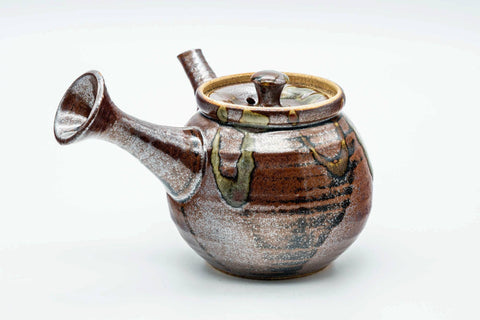 Side view of the kyusu with the handle to the left, lid on, showing the flared spout.