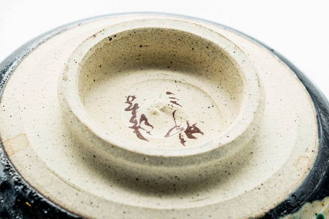 Closeup of the foot and exposed clay base of the black metallic chawan