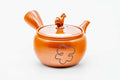 Red shudei Tokoname-yaki side-handle kyusu with a sculpted horse-figure lid knob, three-quarter view with lid on and spout to the left