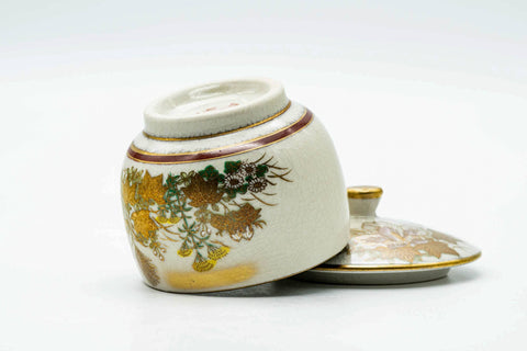 The cup on its side with the lid beside, showing the base.