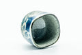 The cup tipped to reveal the speckled glazed interior.