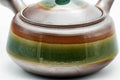 Three-quarter view highlighting the green ash-glaze band around the body.