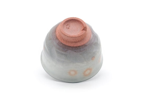 Inverted view showing the terracotta foot and pink-spotted base.