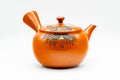 Red shudei Tokoname-yaki side-handle kyusu, three-quarter view with the spout to the left, side handle to the right and lid in place.