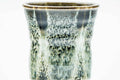 Three-quarter view of the tall yunomi highlighting the drip-glaze texture and pale rim.