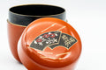 Japanese Natsume - Orange Gold Floral Lacquered Matcha Tea Caddy - 100ml - top-down closeup of the lid showing the gold-trimmed floral fan motif