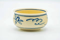 Side angle of the kensui showing more of the hand-painted blue dragonfly and grass design on the beige glaze.