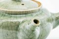 Closeup of the green celadon Obori Soma kyusu with lid on, showing the crackle glaze and spout