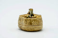 The basket-form kogo with lid on, three-quarter view showing its woven texture, gold-toned glaze and small loop knob.