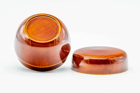 The orange ko-natsume tipped to show its rounded base next to the separate lid.