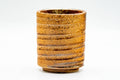 Side view of the Shigaraki-yaki yunomi showing the horizontal spiral ridges wrapping its cylindrical orange clay body