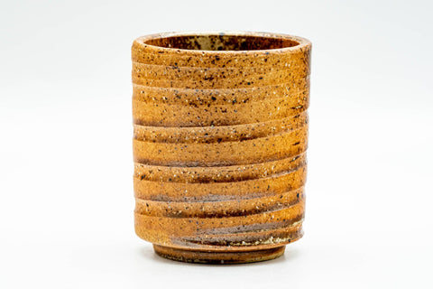 Side view of the Shigaraki-yaki yunomi showing the horizontal spiral ridges wrapping its cylindrical orange clay body