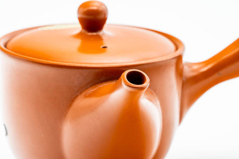 Close-up of the spout and lower body showing the smooth red shudei clay.