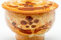Close-up of the cup body showing the orange Shino glaze and reddish floral motif.