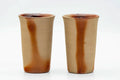 The pair of tall orange cups viewed from a slightly different angle.