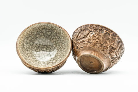 Two guinomi at an angle revealing the green celadon interior glaze