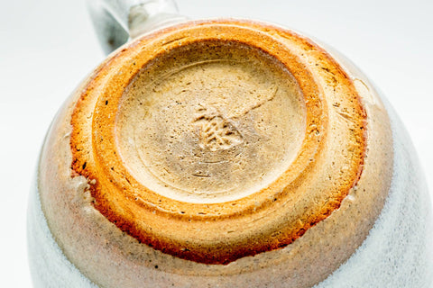 Close-up of the cup's unglazed foot ring and spiral-cut base.