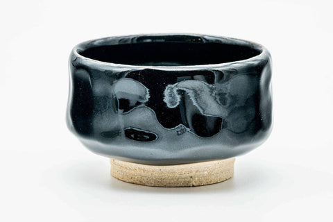 Jet-black chawan, front view showing the glossy glaze and a brushed motif