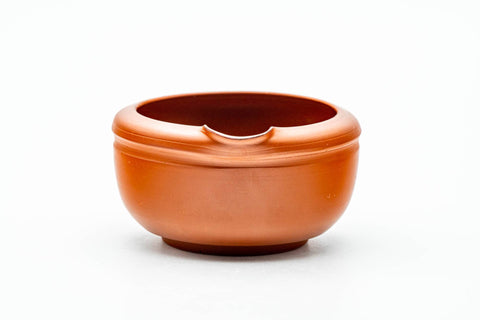 Close-up three-quarter view of the red unglazed katakuchi water cooler, showing its pouring lip and smooth interior.