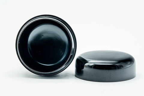 Small black-urushi ko-natsume matcha caddy, lid off, body showing the black interior cavity with the lid underside visible beside it