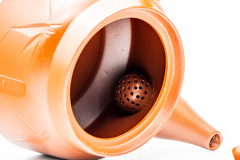 Close-up into the teapot interior showing the built-in ceramic debeso strainer