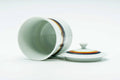 The cup tipped on its side with the lid beside, revealing the interior.