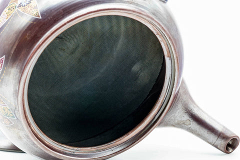 The kyusu with the lid removed, showing the built-in mesh strainer; the lid rests beside it.