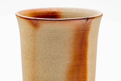 Close-up of a single tall Bizen-yaki cup showing the warm orange wood-fired surface.