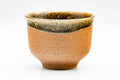 Large orange stoneware yunomi teacup, front view, with a dark brown ash-glaze band dripping down from the rim.