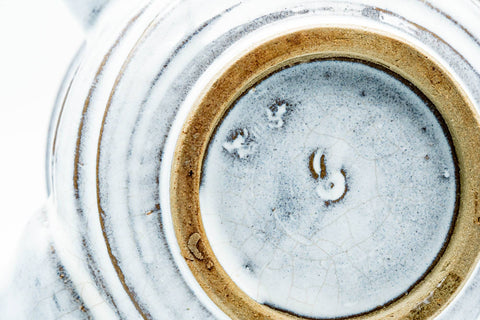 Underside of the teapot showing the unglazed foot ring and a small painted maker's mark.