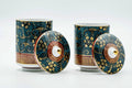 Pair of Kutani-yaki lidded teacups with deep blue glaze and gold floral patterns, one lid removed and one lid on.