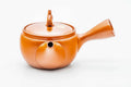 Red shudei Tokoname kyusu, three-quarter view from the rear with the spout to the right