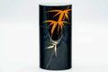 Front view of the tall canister highlighting the orange leaf design against the black body