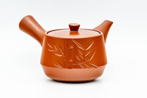 Front view of the side-handle teapot showing the spout, handle and engraved bamboo decoration.