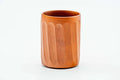 Cylindrical red shudei clay teacup with carved vertical facets, front view.
