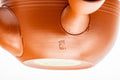 Japanese Kyusu - Spiraling Red Shudei Tokoname-yaki Mesh Teapot - 250ml - closeup of the underside showing the maker's stamp
