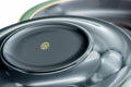 Close-up of a saucer well with a small central mark, framed by the green-trimmed edge.